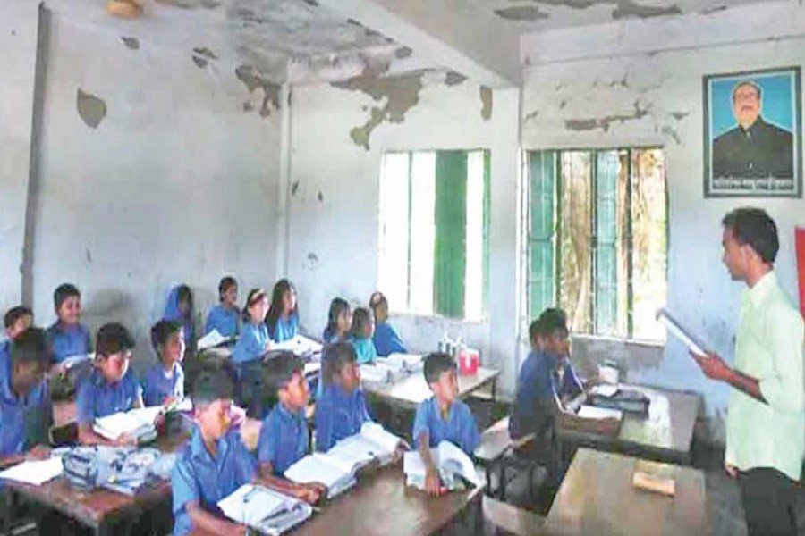 A teacher teaching students in a dilapidated classroom of Choura Government Primary School under Tarash upazila in Sirajganj on Thursday — FE Photo
