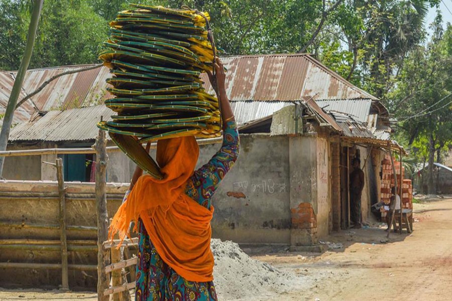 JOYPURHAT: A female vendor selling handfans moving from door to door under Akkelpur upazila of Joypurhat district. — FE Photo