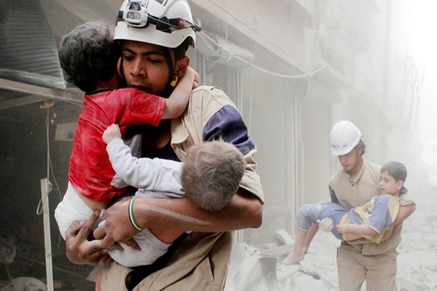 Members of the Civil Defence rescuing children after what activists said was an air strike by forces loyal to Syria's President Bashar al-Assad in Aleppo on Sunday — Reuters