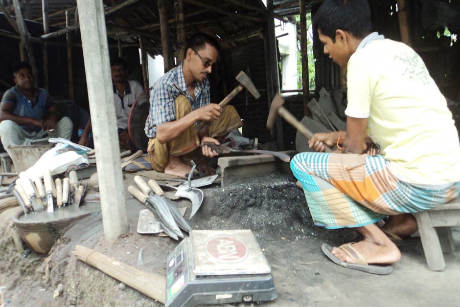Some blacksmiths in Kashira village under Akkelpur upazila of Joypurhat busy making iron tools — FE Photo