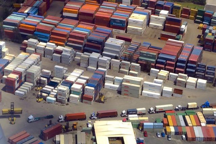 A forklift unloads shipping containers from trucks at a storage facility located near Sydney Airport in Australia — Reuters