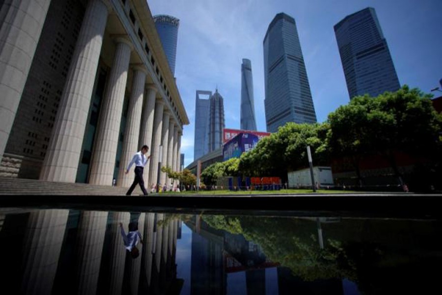 A man walking at Lujiazui financial district of Pudong in Shanghai, China — Reuters