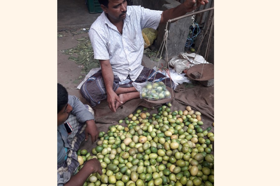 A vendor selling lemon at a wholesale market in Tangail on Monday — FE Photo