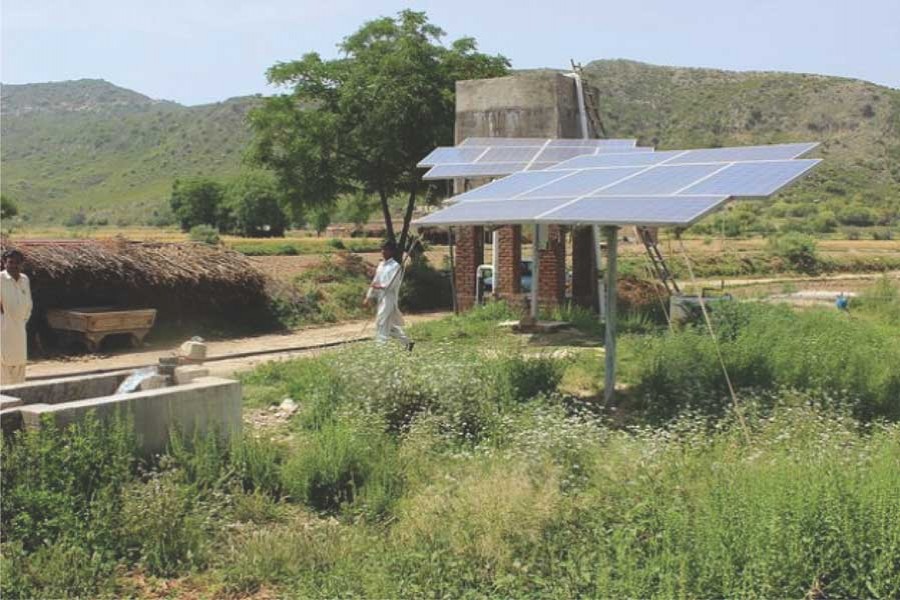 A farmer walks past the solar panels used to pump water in the Soan Valley. The Global Green Growth Institute (GGGI) works closely with countries to diversify their economies, promote solar energies, and connect financial investors with specific green growth projects. — Zofeen Ebrahim/IPS