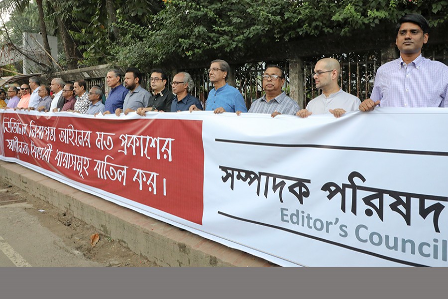 Members of the Editors' Council take part in a human chain in front of the Jatiya Press Club in city on Monday demanding amendment to the Digital Security Act. FE Photo