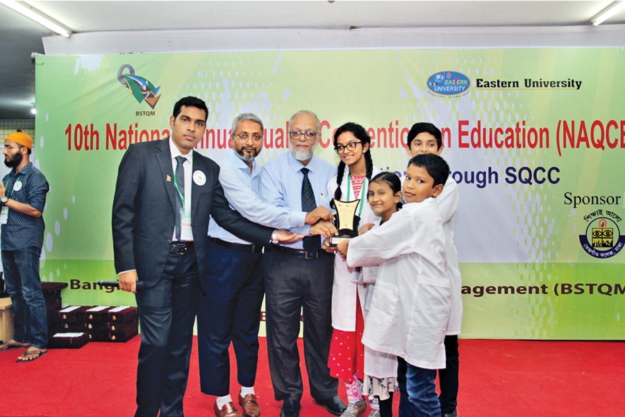 (From left) Master of the ceremony Ather Yeasir Fahim along with convener Md Nuruzzaman Talukder and chief guest Md Abdul Awal, managing director of The Structural Engineers Limited handing over prize to Upgrade International School team