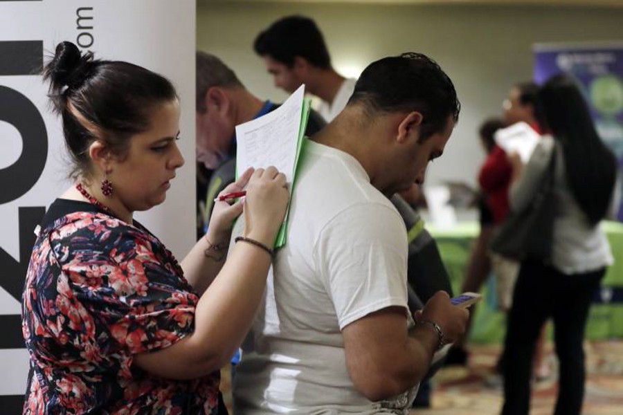 A file photo showing a woman filling out a job application at a JobNewsUSA job fair in Miami Lakes, Fla recently — AP
