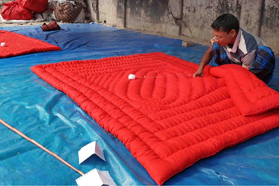 A quilt maker working at his shop in Mohadevpur upazila of Naogaon on Tuesday — FE Photo