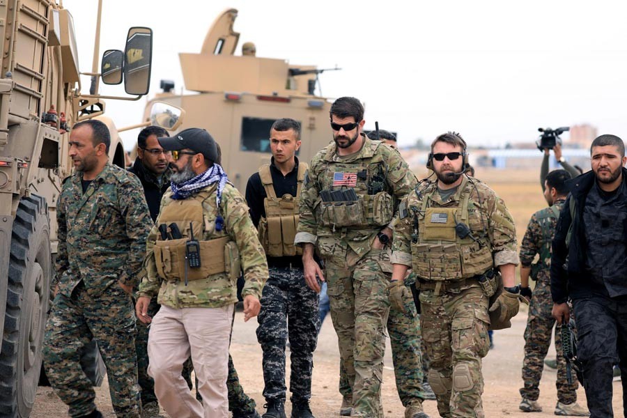 A file photo showing Syrian Democratic Forces and US troops seen during a patrol near Turkish border in Hasakah, Syria recently — Reuters