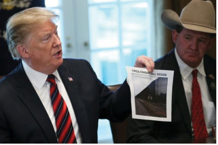 US President Donald Trump shows a photo of a "typical" border wall design during a "roundtable discussion on border security and safe communities" with state, local, and community leaders in the Cabinet Room of the White House in Washington, US on January 11, 2019. —Reuters