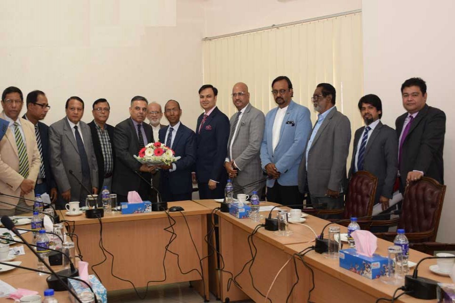 BIDA Executive Chairman Kazi M Aminul Islam (right) receiving a bouquet of flowers from DCCI President Osama Taseer at a meeting in the capital on Tuesday