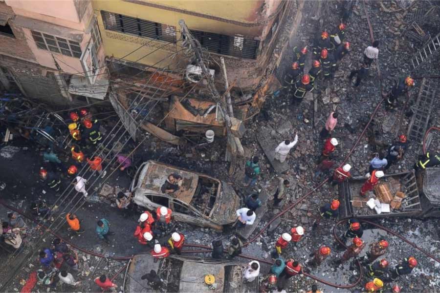 Rescuers stand at the site of Chawkbazar fire of February 20, 2019. —Photo: AP