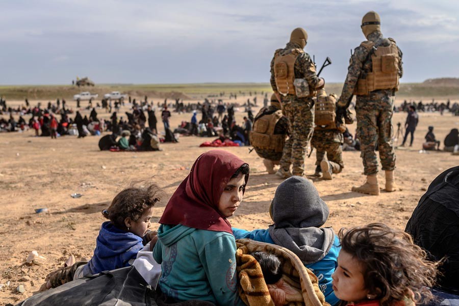 BAGHOUZ: Civilians waiting at a screening area held by the US-backed Kurdish-led Syrian Democratic Forces (SDF), in Baghouz area on Wednesday — AFP