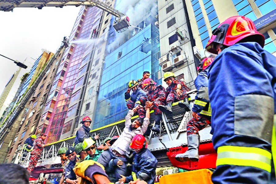 Fire-fighters rescuing a person after a blaze raged through several floors of FR Tower at Banani in the capital on Thursday — FE Photo by Shafiqul Alam
