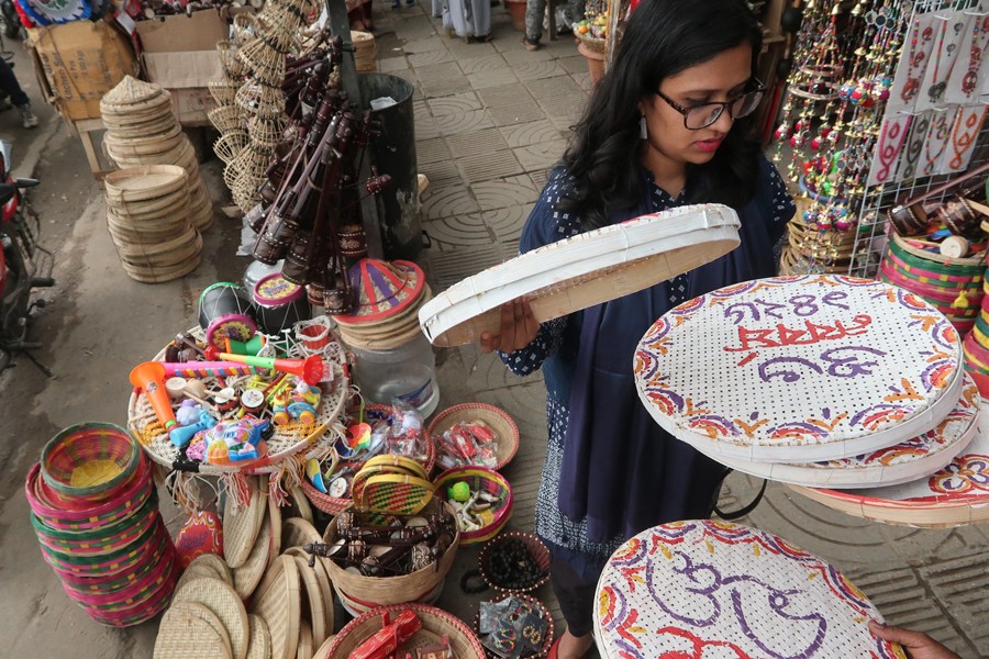 A woman choosing decor items at a shop at Doyel Chattar in Dhaka city ahead of the Pahela Baishakh celebration — FE photo