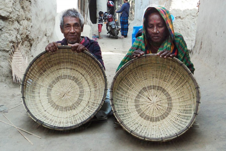 A couple of bamboo basket makers showing their products in Panchbibi upazila of Joypurhat on Wednesday — FE Photo