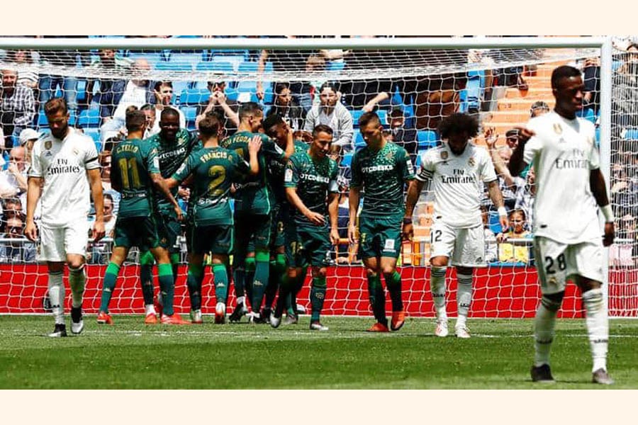 Real Betis' Jese celebrating with teammates after scoring their second goal as Real Madrid's Nacho and Marcelo look dejected on Sunday — Reuters