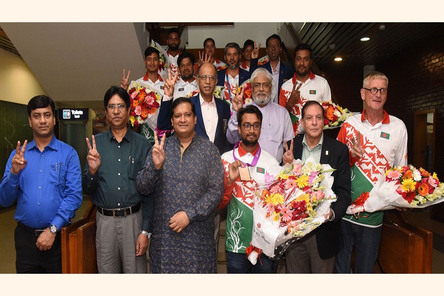Archer Mohammad Ruman Shana poses for photograph with Bangladesh team at a reception on Tuesday —UNB