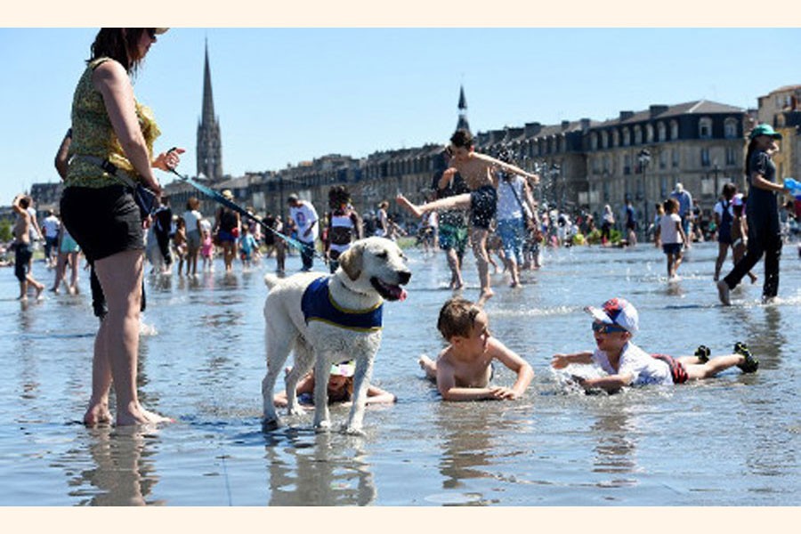 A family spending time in sea beach with their pet dog as temperature hit 40 degrees in France breaking the record for June — BBC