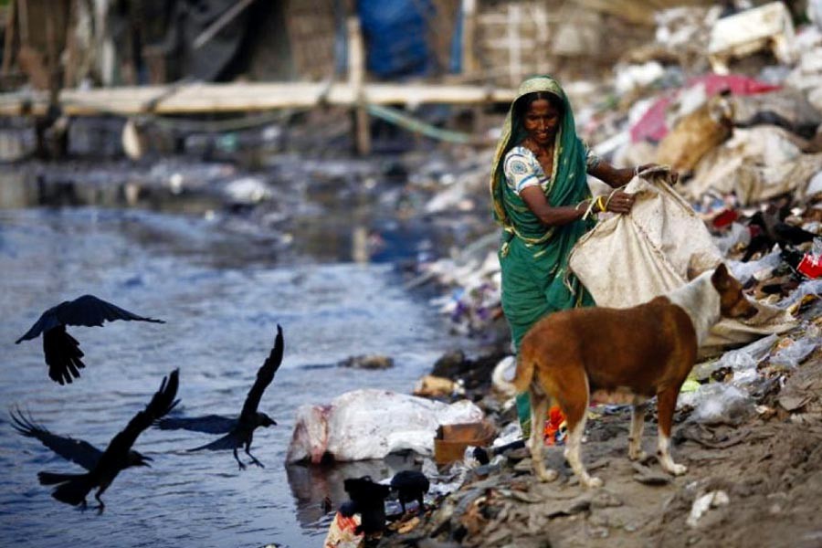 A woman collects garbage from a dump along the polluted Buriganga river in Dhaka, Bangladesh. —Photo: Reuters