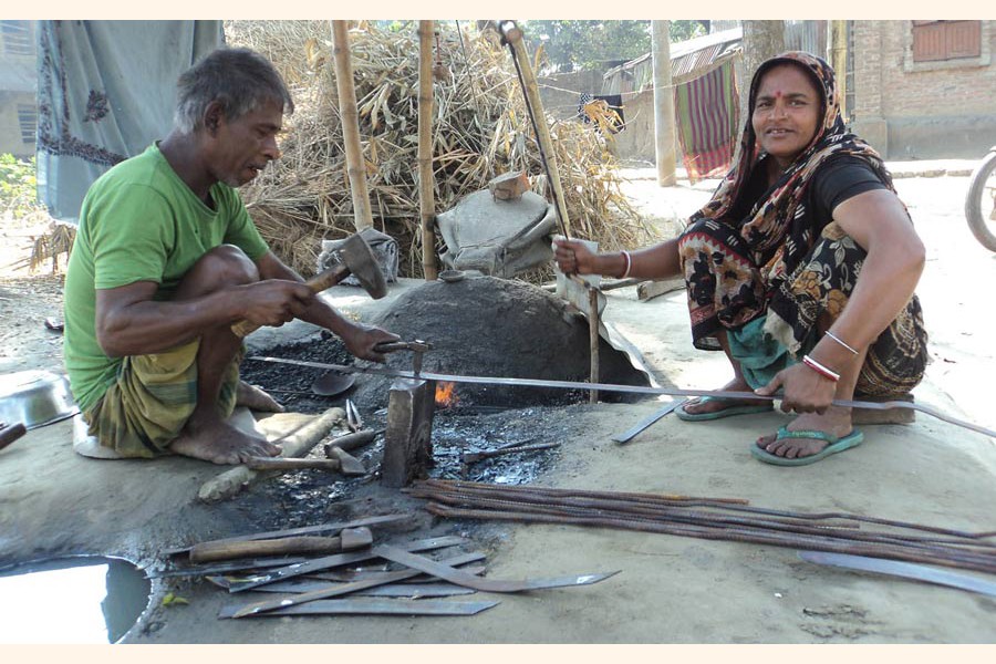 A couple of blacksmith under Panchbibi upazila of Joypurhat busy making varieties of iron tools on Thursday — FE Photo