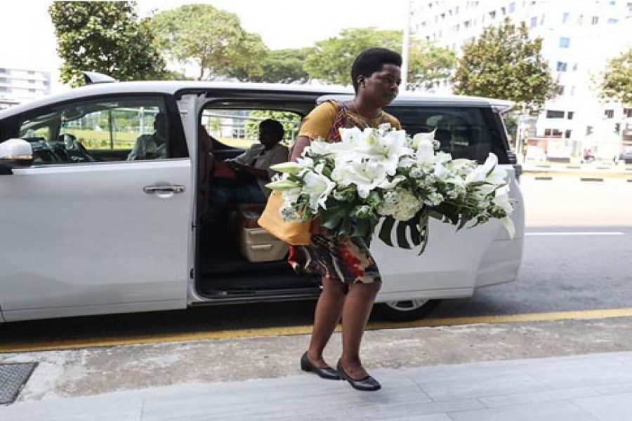 A visitor arrives with a wreath at the Singapore Casket funeral parlor building where the body of Robert Mugabe was being held on September 07, 2019, in Singapore. — Photo: AP