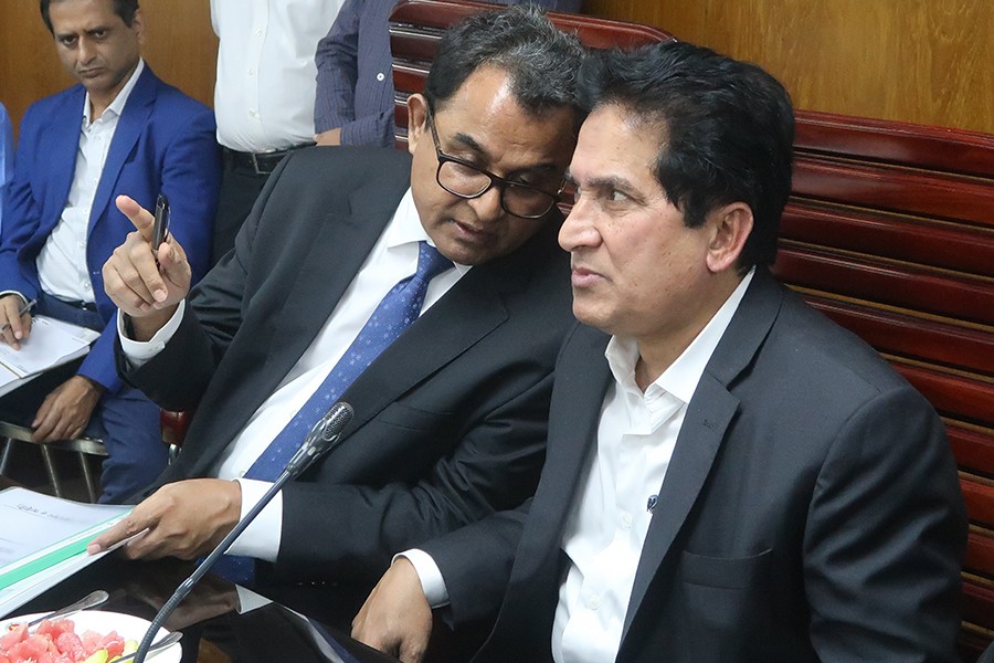Finance Minister AHM Mustafa Kamal talking to NBR chairman Md Mosharraf Hossain Bhuiyan on Sunday — FE Report