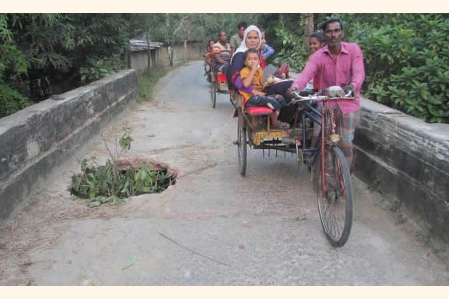 A big pothole has been developed in the middle of 40-year-old concrete bridge over the Shiholy canal in the Durgapur area under Kalai upazila of Joypurhat district — FE Photo