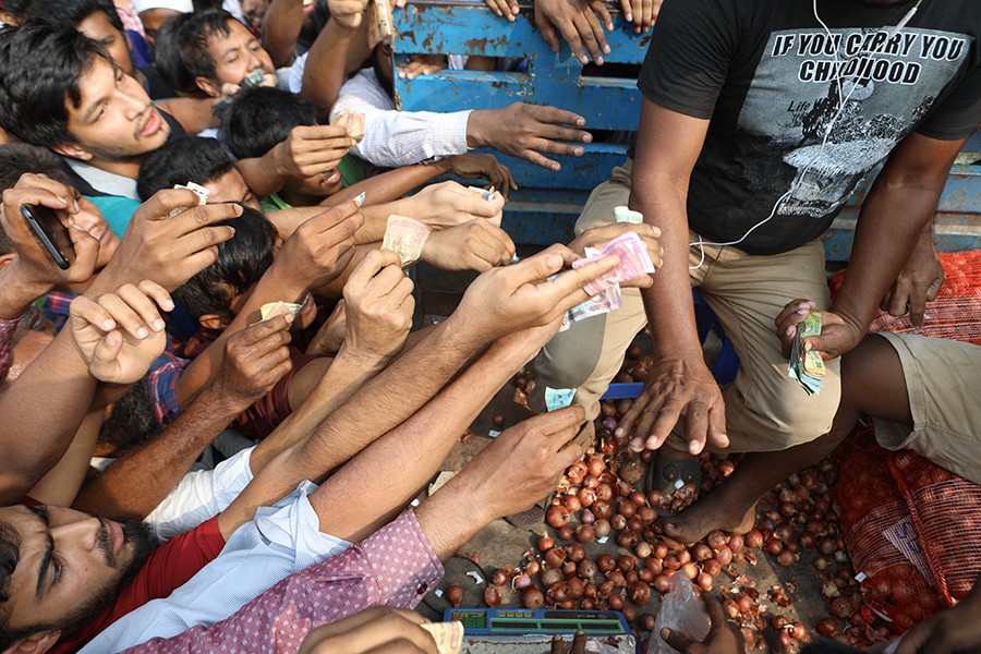 Consumers' frantic efforts to purchase onion at Tk 45 per kg from a TCB-operated truck at Khamarbari in the capital on Sunday amid the soaring prices of the essential — FE Photo by Shafiqul Alam