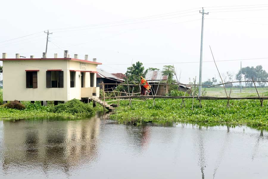 A patient using a bamboo-bridge to go to Hatgram Community Clinic under Bhangura upazila in Pabna district as it is the only way to reach the health centre — FE Photo