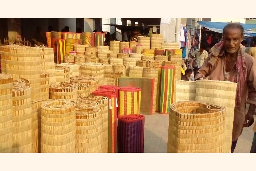 A mele mat seller waiting for buyers at his shop at a market in Satkhira district — UNB Photo