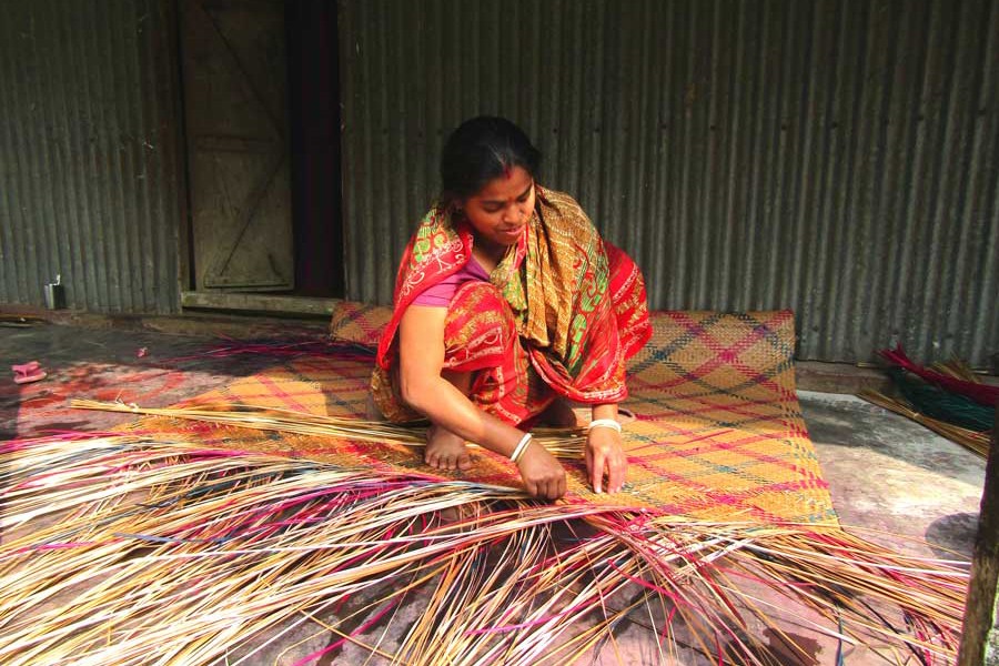 A female artisan weaving mat at her homestead in Mymensingh district — FE Photo