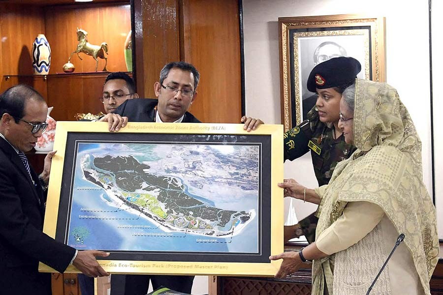 Prime Minister Sheikh Hasina receiving a master plan of a eco-tourism park, to be developed at Cox’s Bazar, from concerned officials during a meeting at PMO in Dhaka on Wednesday. -PID Photo