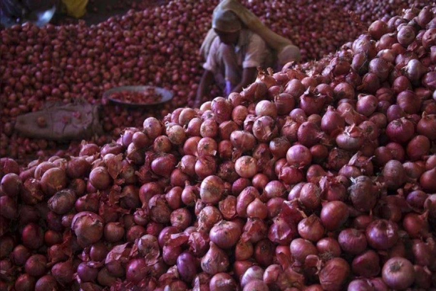A worker sorts onions at a wholesale vegetable market in Chandigarh, India, July 24, 2015 — Reuters/Files