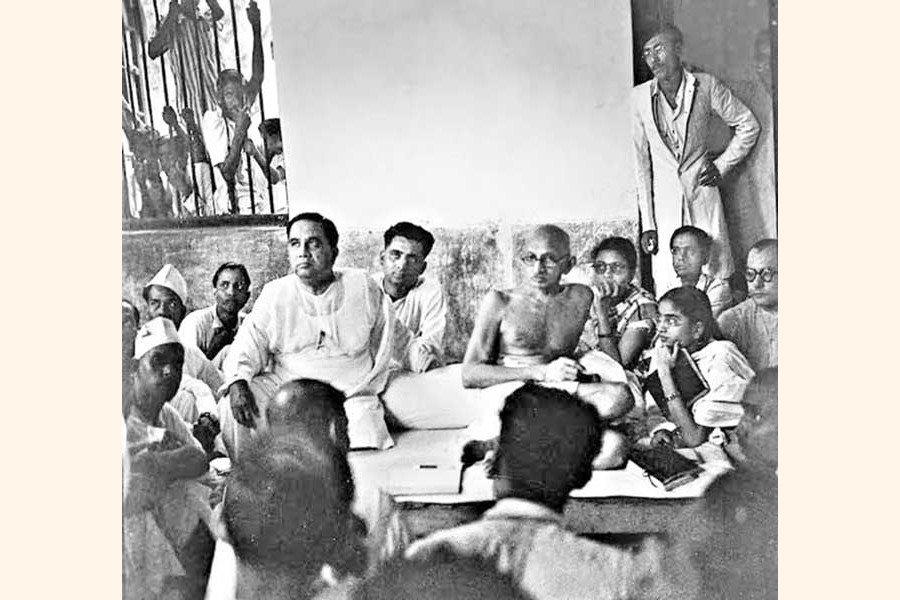 Sheikh Mujibur Rahman, the young student leader (standing at the back) and Huseyn Shaheed Suhrawardy with Mahatma Gandhi in Kolkata. They were there to support Mahatma Gandhi's protest against the Hindu-Muslim communal riots (1947) — mujib100.gov.bd