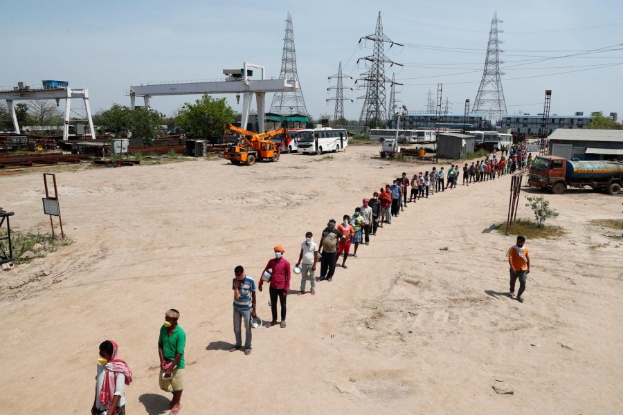 FILE PHOTO: Daily wage labourers stand in a queue for free food at a construction site where activity has been halted due to 21-day nationwide lockdown to slow the spreading of the coronavirus disease (COVID-19), in New Delhi, India, April 10, 2020. REUTERS/Adnan Abidi/File Photo