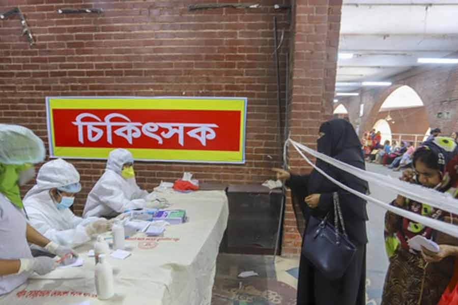 Patients with symptoms of cough and fever, which are similar to those of COVID-19, taking treatment at separate counter opened by Shaheed Suhrawardy Medical College Hospital in Dhaka for providing one-stop services amid a global coronavirus outbreak – bdnews24.com photo