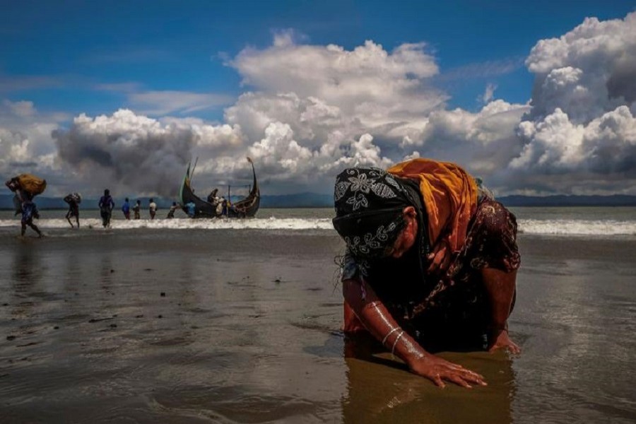 Representational image: An exhausted Rohingya refugee woman touches the shore after crossing the Bangladesh-Myanmar border by boat through the Bay of Bengal, in Shah Porir Dwip, Bangladesh, September 11, 2017. — Reuters/Files