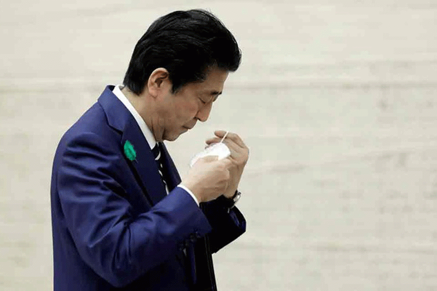 Japan's Prime Minister Shinzo Abe puts on a protective mask after a news conference at the prime minister's official residence in Tokyo, Japan Apr 17, 2020. REUTERS