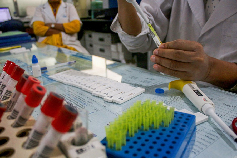 A lab technician tests the presence of dengue virus in blood sample at a hospital in Dhaka — VCG via China Daily