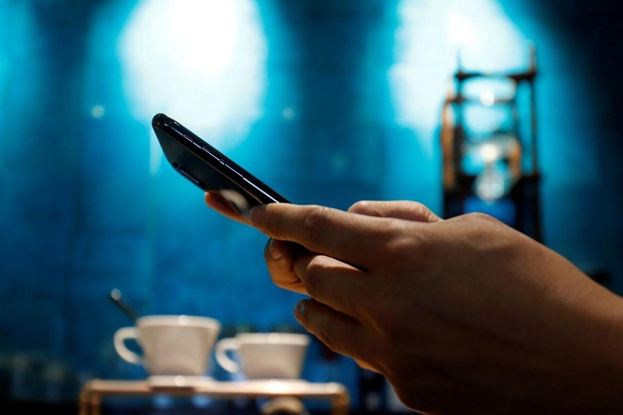 A man uses a mobile device in a coffee shop in Hanoi, Vietnam, May 18, 2018. — Reuters