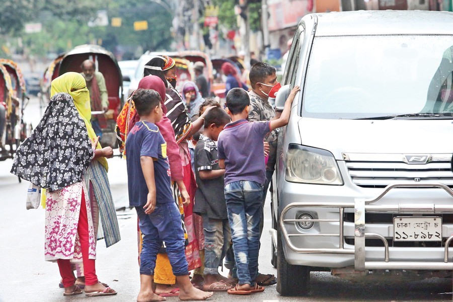 Poor people pleading for alms at Bailey Road in the city on Friday — FE photo