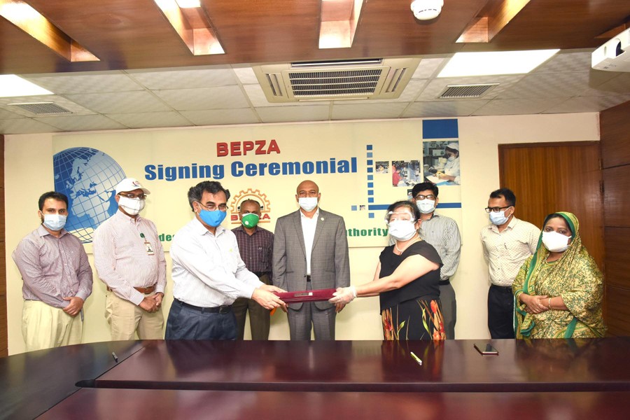 Mr Mohammad Faruque Alam, Member (Engineering) of BEPZA and Ms Kang Yanhong, Managing Director of M/s Unicorn Leather Goods Factory Ltd seen exchanging documents on behalf of their respective organisations