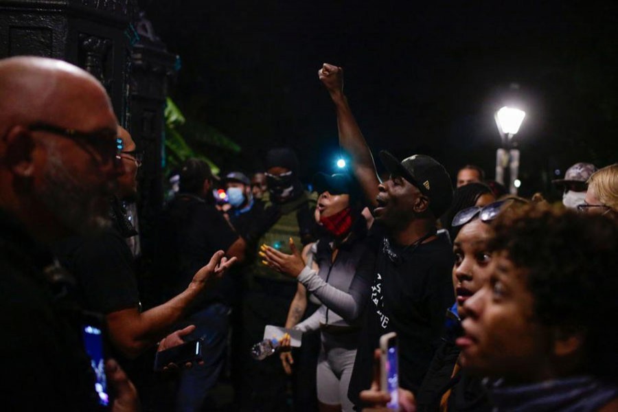 Several men stand at the locked gates of Jackson Square, where a statue of Andrew Jackson resides, and had brief heated words with demonstrators who had gathered around the square during a protest against the death in Minneapolis police custody of George Floyd, in New Orleans, Louisiana, U.S., June 5, 2020. Picture taken June 5, 2020. REUTERS/Kathleen Flynn