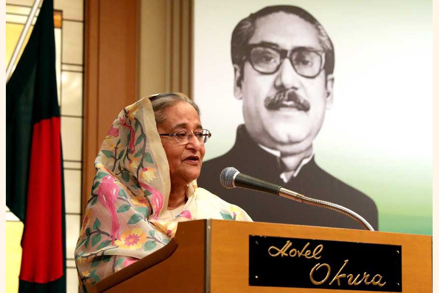 Prime Minister Sheikh Hasina at a reception in Japan last year with the portrait of Father of the Nation Bangabandhu Sheikh Mujibur Rahman in the background — Website of Bangladesh Awami League