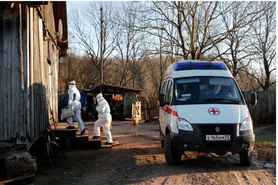 Paramedics wearing personal protective equipment (PPE) enters the house of a patient, amid the outbreak of the coronavirus disease (COVID-19) in the village of Vybiti, Novgorod Region, Russia Dec 10, 2020. REUTERS