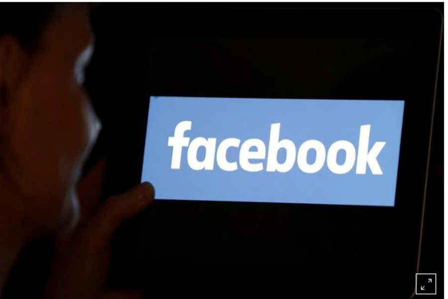 FILE PHOTO: A woman looks at the Facebook logo on an iPad in this photo illustration taken June 03, 2018. REUTERS/Regis Duvignau/Illustration/
