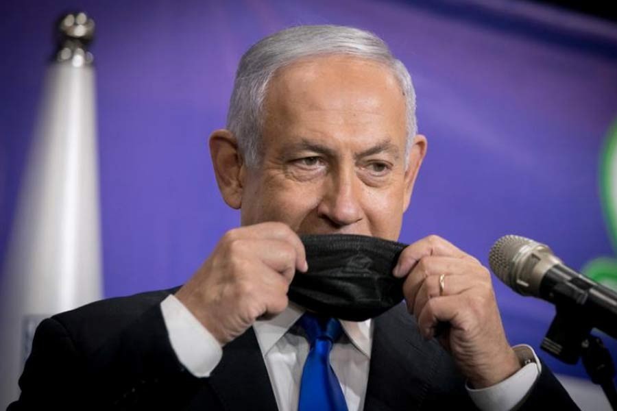 Israeli Prime Minister Benjamin Netanyahu adjusts his mask during a news conference in Tel Aviv on March 8 –Reuters file photo