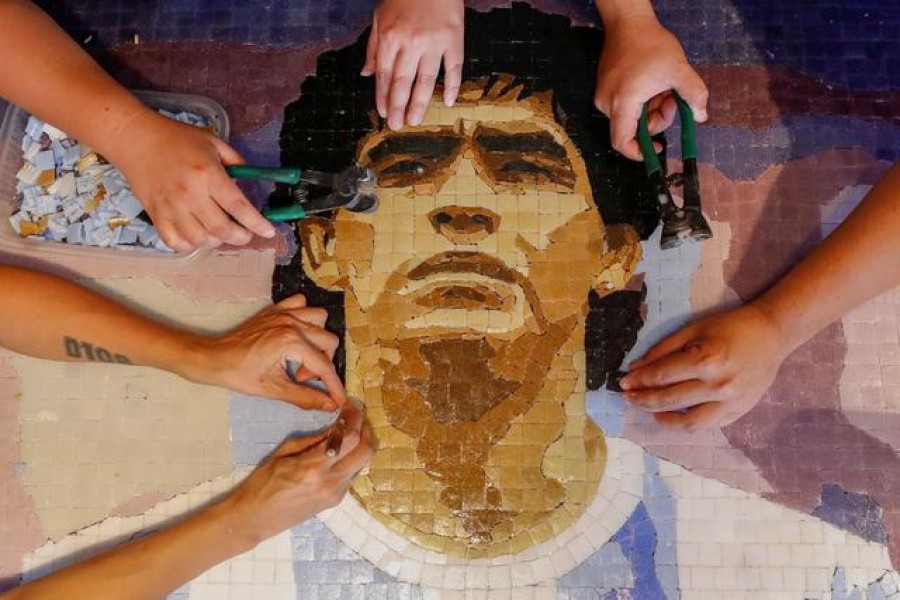 FILE PHOTO: Gabriela Pereyra, Paula Soto, ad Gonzalo Lopez Lluch, members of the cultural organisation Comando Maradona, prepare a mosaic as a homage to late Argentine soccer superstar Diego Armado Maradona, at their workshop, in Buenos Aires, Argentina February 24, 2021. Picture taken February 24, 2021. REUTERS/Agustin Marcarian
