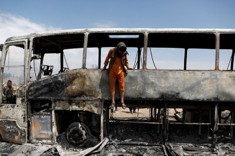 A man jumps out of a burnt bus after an overnight fire, on the outskirts of Kabul, Afghanistan May 2, 2021. Reuters